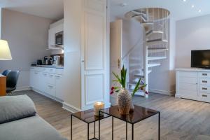 a living room with a coffee table and a spiral staircase at Sylt-Traum Kampen in Kampen
