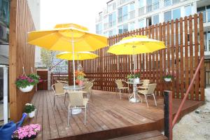 a wooden deck with two tables and two yellow umbrellas at Han River Residence & Guesthouse in Seoul
