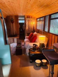 a living room with a bed and a table with a lamp at The Bus In The Woods in Belturbet