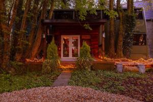 a house with a front porch with trees and lights at The Bus In The Woods in Belturbet