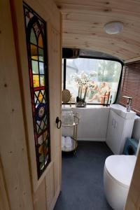 a bathroom with a toilet and a stained glass window at The Bus In The Woods in Belturbet