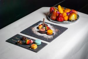 two plates of food on a table with fruit at Tower Club at lebua in Bangkok