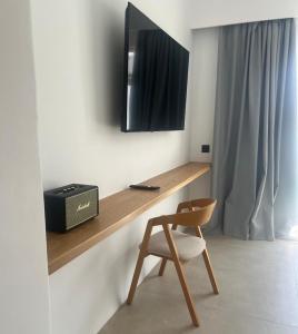 einen Schreibtisch mit Stuhl und einen TV an der Wand in der Unterkunft Mykonos Drops in Platis Gialos