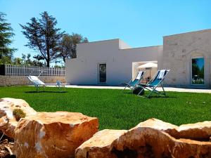 a house with two lawn chairs in a yard at Pietra Di Puglia in Monopoli