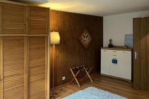 een kamer met een houten wand met een koelkast en een lamp bij Chalet Oasis - Swiss Ski Retreat in Bürglen +17 foto's