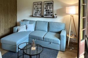 un divano blu in un soggiorno con un tavolo di Chalet Oasis - Your Alpine Hideaway a Bürglen