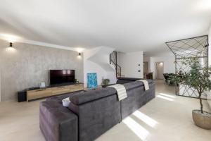 a living room with a large couch and a tv at Villa Petrina in Sveti Petar u Šumi