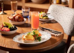 een houten tafel met borden eten en drinken bij The BoTree - Preferred Hotels and Resorts in Londen