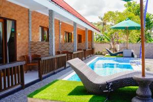 a pool with a chair and an umbrella next to a house at DESILA Beach House in Nusa Penida