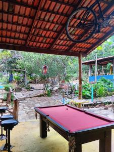 a ping pong table under awning in a patio at Chalé Rio Piscina Cozinha Área de Lazer Pertinho da CidadeMaravilha in Pirenópolis +31 photos