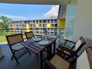a dining table on a balcony with a view of a building at Casa Romana Aqua Apartman in Siófok +10 photos