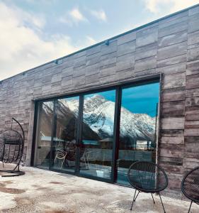a group of chairs sitting in front of a building at Alpine Escape Kazbegi in Stepantsminda
