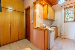 una cucina con mobili in legno e un lavello di One bedroom apartment Vasillis a Paleokastritsa Altre 15 foto