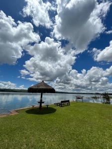 a picnic table and an umbrella next to a lake at Pontal da lagoa in Planaltina