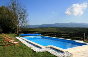 a swimming pool with a bench and a chair next to it at Il-Veduta: Country-estate in Oroslavje
