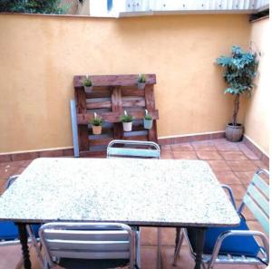 a table and chairs on a patio with potted plants at Warm apartment - Lleida in Lleida