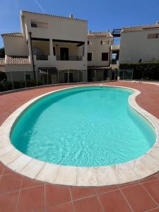 a large swimming pool in front of a building at CASTELSARDO Casa Raoul Piscina e vista mare in Castelsardo