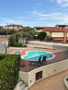 a swimming pool with two chairs next to a building at CASTELSARDO Casa Raoul Piscina e vista mare in Castelsardo