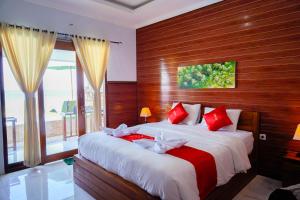 ペニダ島にあるDESILA Beach Houseのベッドルーム1室(赤と白の弓を用いたベッド2台付)
