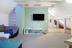 a living room with a couch and a tv on a wall at Ferienwohnung am Schlosssee in Salem