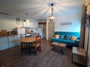a living room with a table and a blue couch at Évasion rustique et confortable in Saint-Lumier-la-Populeuse