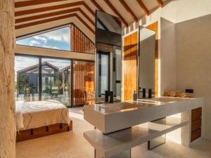 baño con lavabo, cama y ventana en Blacksand Villas Echo Beach Canggu A4, en Canggu 17 fotos más