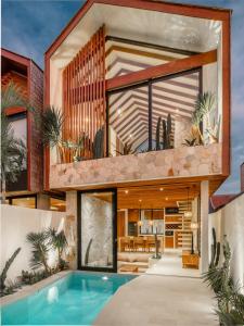 Una vista exterior de una casa con piscina. en Blacksand Villas Echo Beach Canggu A4, en Canggu