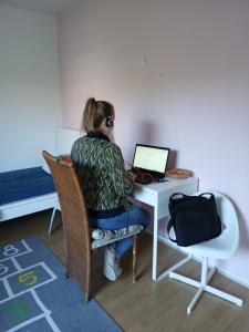 a woman sitting at a desk with a laptop computer at nys willy in Grimbergen