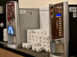 a counter with cups and a coffee maker on it at Imperial Hotel Kuching in Kuching