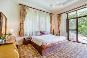 a bedroom with a bed and a large window at Huahin I-Din Poolvilla วิลล่ากลางธรรมชาติ วิวภูเขา เป็นส่วนตัว in Hua Hin