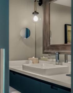een badkamer met een witte wastafel en een spiegel bij Newport Harbor Island Resort in Newport