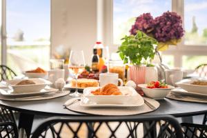 a table with plates of food and wine glasses at Golden Poodle Luxusappartment am Neuen Schloss Tettang in Tettnang