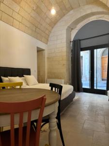 a bedroom with a bed and a table and a bed and a room at Alora boutique suites in Lecce +52 photos
