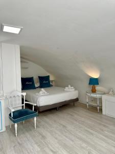 a bedroom with a bed with blue pillows and a chair at Martucci 83 in Naples