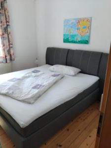 een bed in een kamer met een grijze bank bij Ferienwohnung Linde bei Ferienwohnungen May in Plankenfels