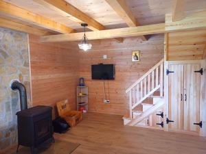 ein Zimmer mit einem Kamin und einer Treppe in einem Blockhaus in der Unterkunft Brvnara Smrčica in Bajina Bašta