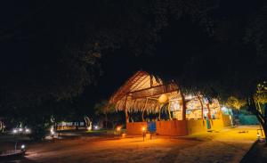 a large building with a thatched roof at night at Yakaduru - Yala in Yala