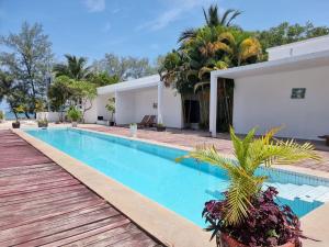 a swimming pool in front of a house at Mittali Beach Hotel in Sihanoukville