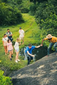 a group of people are standing by a river at Yakaduru - Yala in Yala