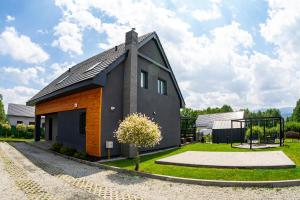 ViewMountain - Apartamenty Cieplice في يلينيا غورا: منزل أسود وبرتقالي بسقف مثلث الشكل