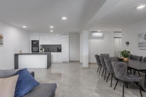 a living room with a table and chairs and a kitchen at Spacious Pool Apartment Crikvenica - Happy Rentals in Crikvenica