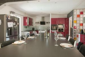 a kitchen with a long table with plates and wine glasses at Maison 4 chambres avec piscine in Saint-Gilles