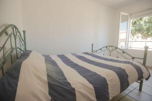 a bed with a striped blanket on it in a bedroom at Maison 4 chambres avec piscine in Saint-Gilles +13 photos