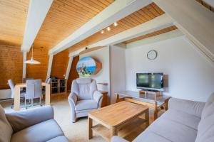 ein Wohnzimmer mit Couch und Fernseher in der Unterkunft Ferienwohnpark Immenstaad am Bodensee Nurdachhaus Typ 8 NDT 014 in Immenstaad am Bodensee + 12 Fotos