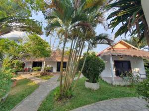 a house with a palm tree in front of it at Mittali Beach Hotel in Sihanoukville