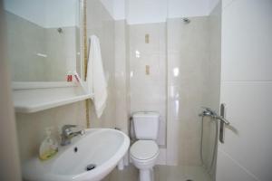a white bathroom with a toilet and a sink at thalassa home in Nikiana