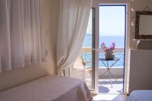 a bedroom with a bed and a view of the ocean at thalassa home in Nikiana