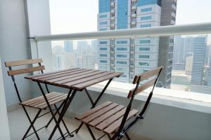 a wooden table and two chairs on a balcony at Comfort in Sharjah