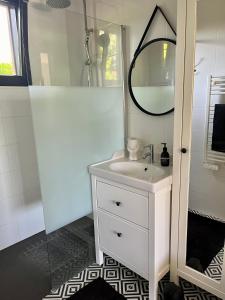 a white bathroom with a sink and a mirror at Casa Tagomago in Andernos-les-Bains