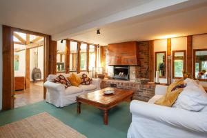 a living room with two white couches and a fireplace at DADIO's Barn - Indoor Swimming Pool 400 Years Old & Hot tub in Kent